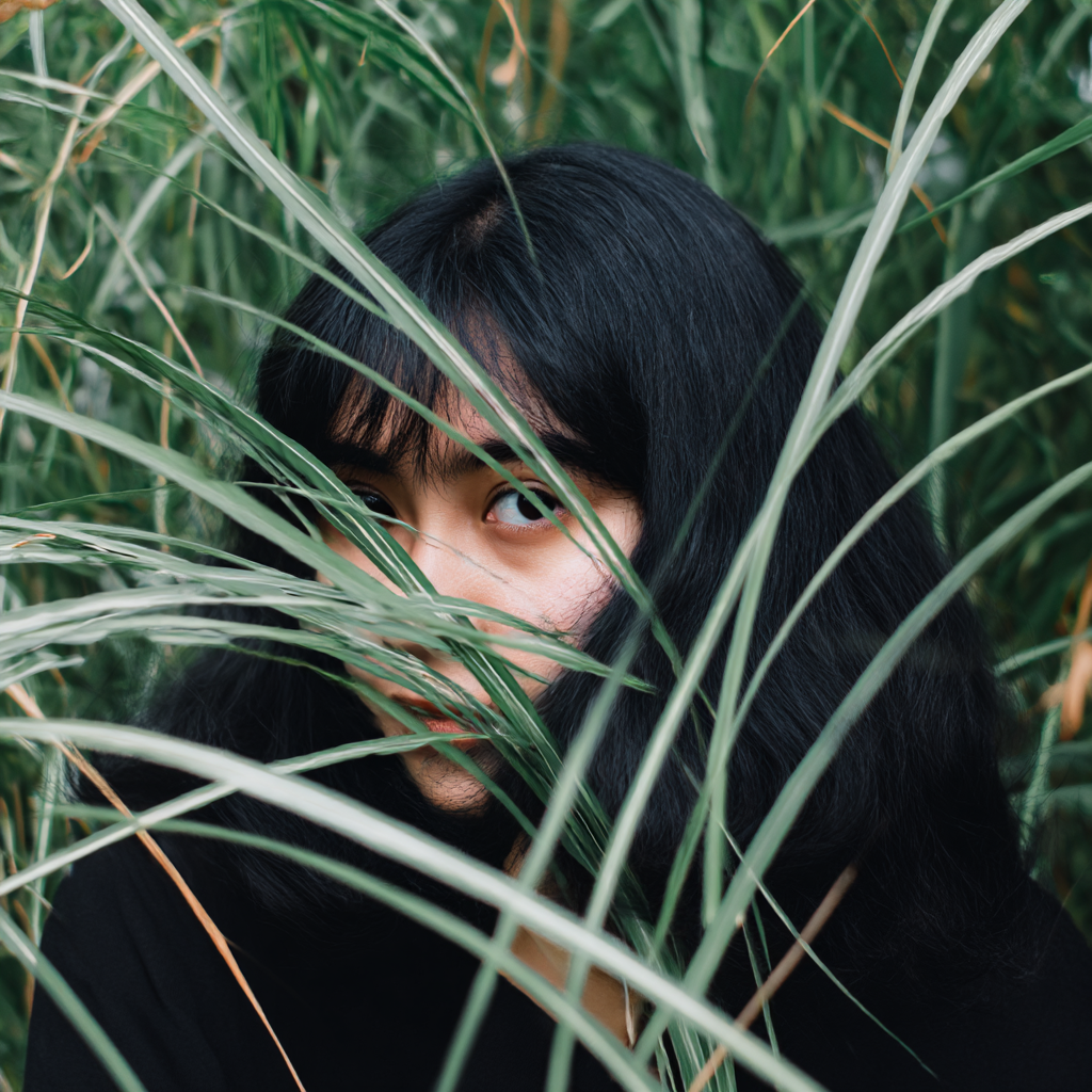 sebastian069710_A_woman_with_black_hair_hiding_behind_some_gr_27b1db72-9e2b-4d6f-ad17-6c8d3b831fb5_3